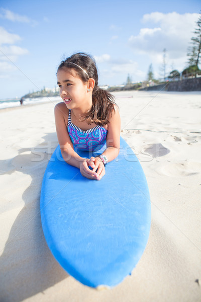 Cute joven tabla de surf azul playa mirando Foto stock © ElinaManninen