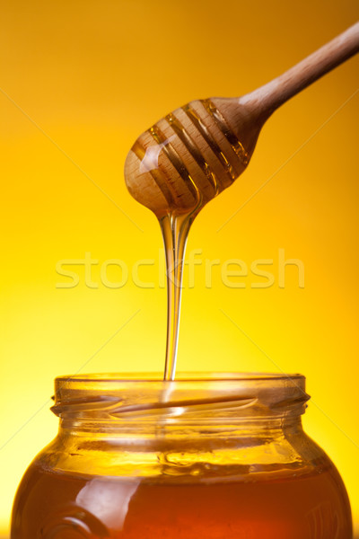 Stock photo: Wooden dipper with flowing honey 