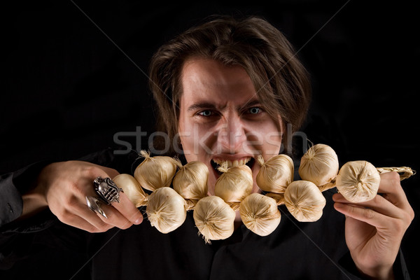 Evil vampire with scary eyes eating garlic   Stock photo © Elisanth