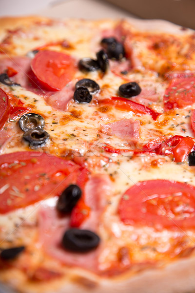 Close-up shot of tasty Italian pizza with ham, tomatoes and oliv Stock photo © Elisanth