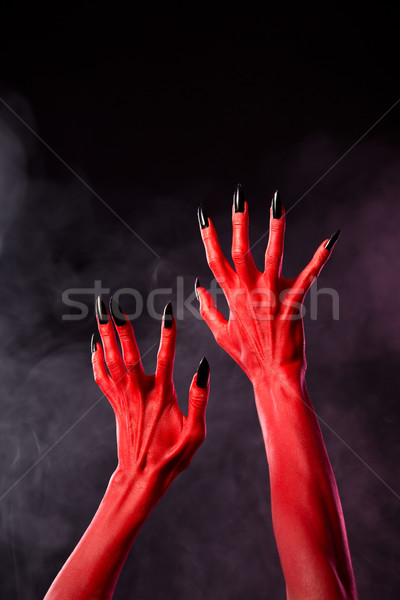 Stock photo: Red devil hands with black sharp nails, extreme body-art 