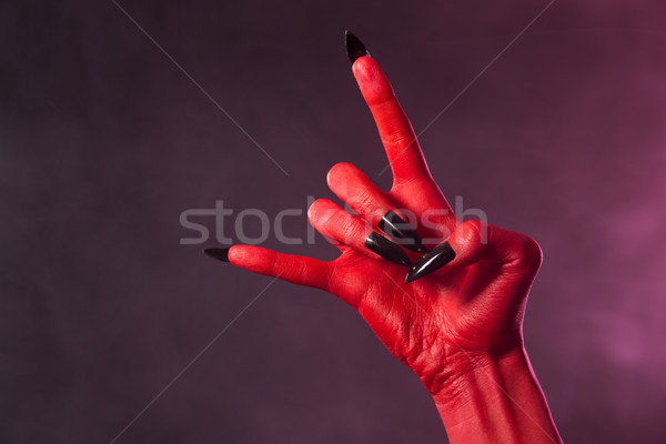 Red devil hand with black nails, heavy metal gesture  Stock photo © Elisanth