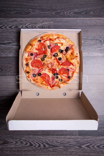 Top view of Italian pizza with ham, tomatoes, and olives in box  Stock photo © Elisanth