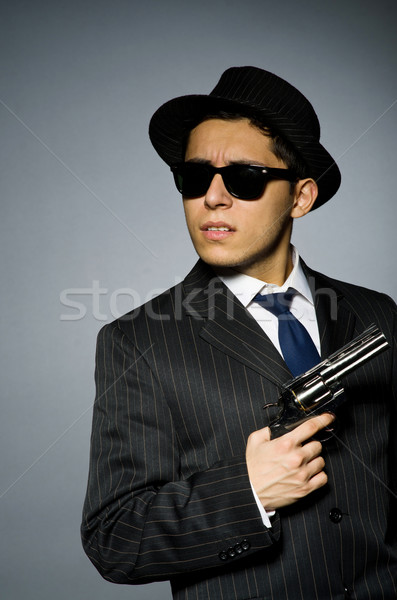 Young man in classic striped costume holding gun isolated on gray Stock photo © Elnur