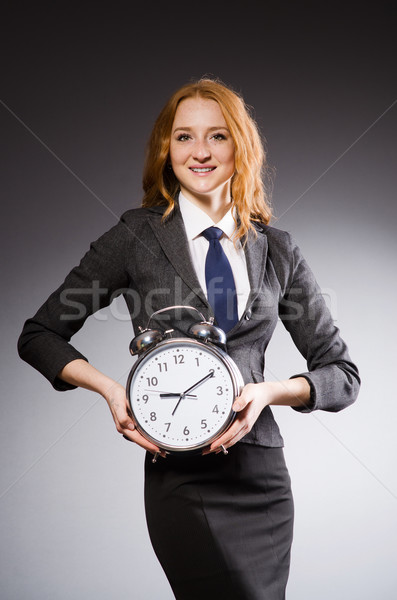 Businesswoman with clock being late for her deliverables Stock photo © Elnur