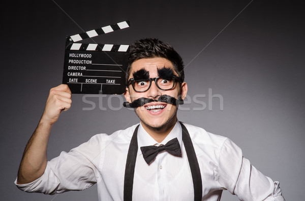 Young man with false moustache holding clapperboard isolated on  Stock photo © Elnur