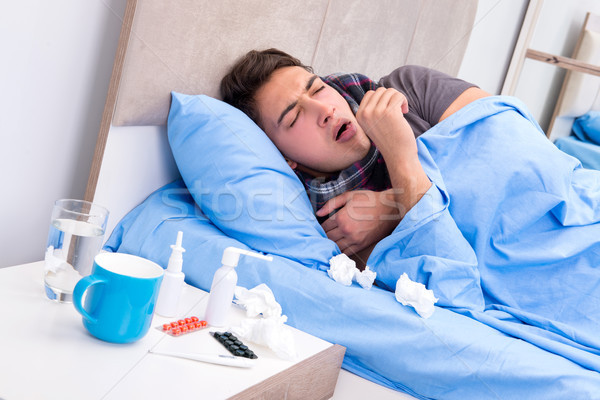 Sick man with flu lying in the bed Stock photo © Elnur