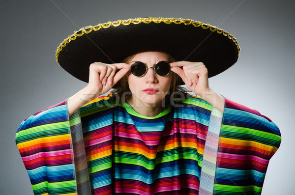 Girl in mexican vivid poncho against gray Stock photo © Elnur