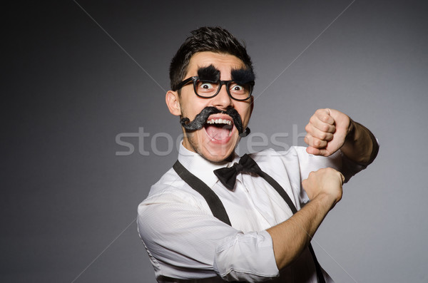 Young man with false moustache isolated on gray Stock photo © Elnur