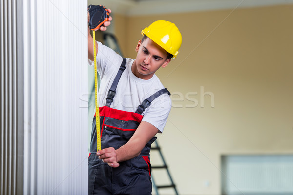 Young repairman with tape measure working on repairs Stock photo © Elnur