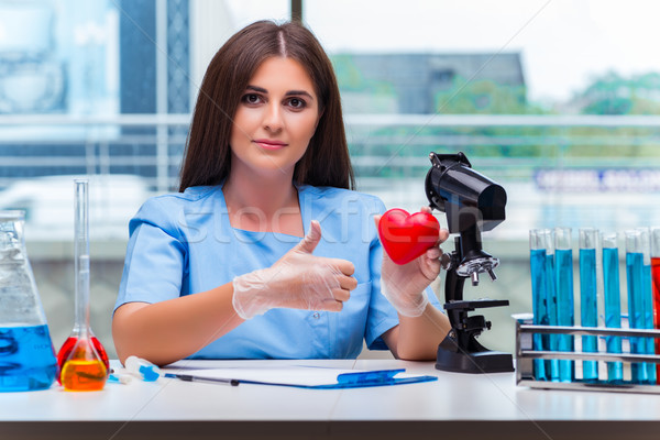 Young doctor with red heart in lab Stock photo © Elnur