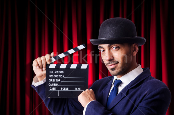 Stock photo: Man with movie clapper on curtain background