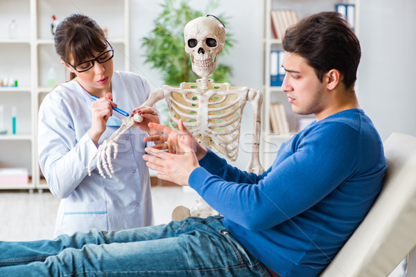 The doctor showing type of injury on skeleton to patient Stock photo © Elnur