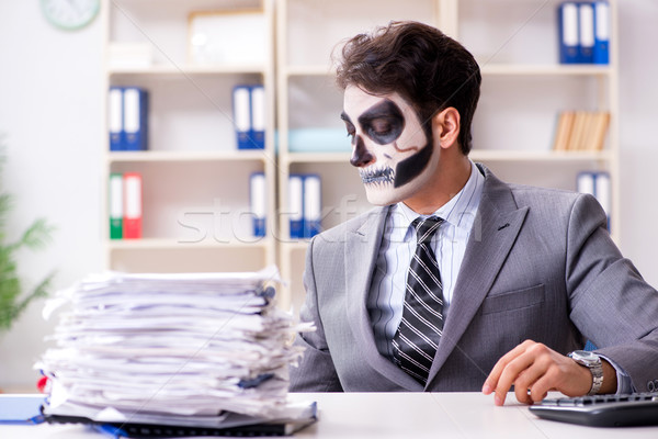 Stock photo: Businessmsn with scary face mask working in office