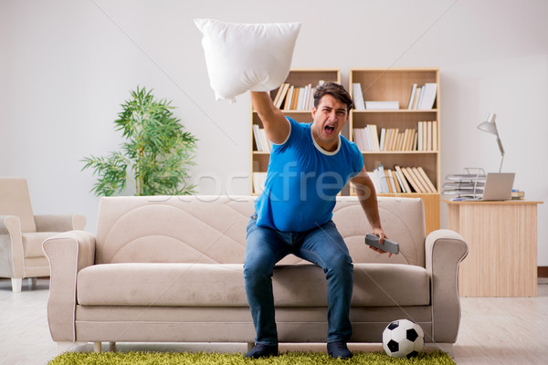 Człowiek oglądania piłka nożna domu posiedzenia kanapie Zdjęcia stock © Elnur