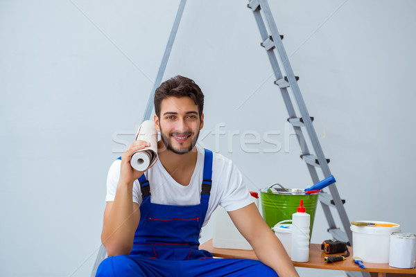 Repairman doing renovation repair in the house with paper wallpa Stock photo © Elnur