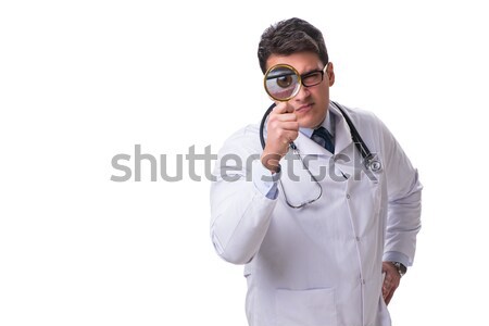 Stock photo: Young male doctor with a looking magnifying glass isolated on wh