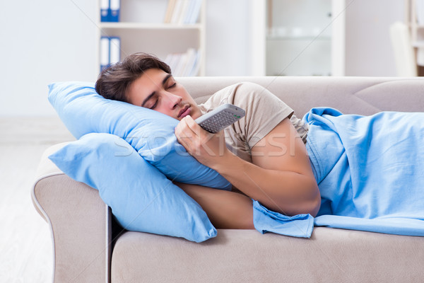 Man watching tv from bed holding remote control unit Stock photo © Elnur