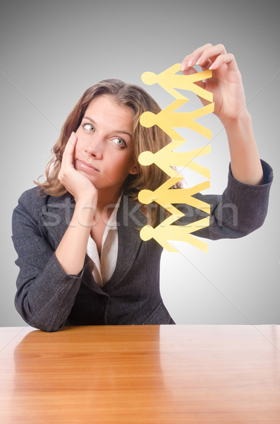 Businesswoman with paper people on white Stock photo © Elnur