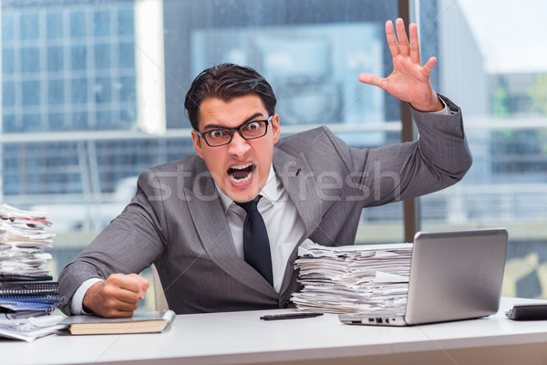 Angry businessman with too much work in office Stock photo © Elnur