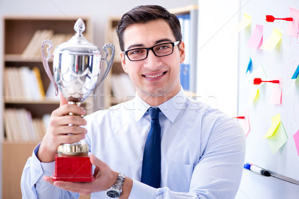 Young businessman receiving prize cup in office Stock photo © Elnur