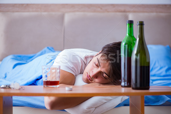 Man alcoholic drinking in bed going through break up depression Stock photo © Elnur
