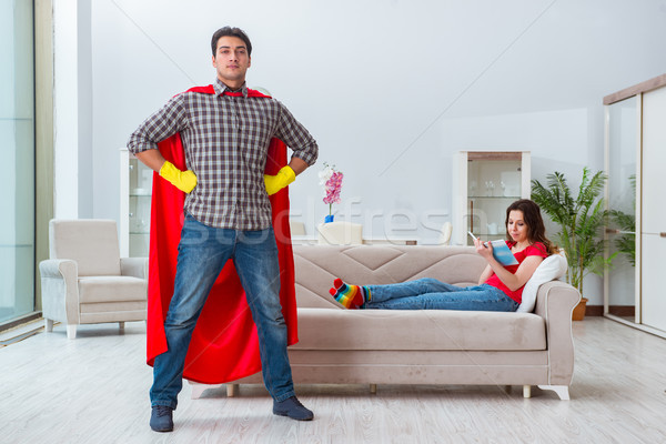 Stock photo: The superhero husband helping his wife at home