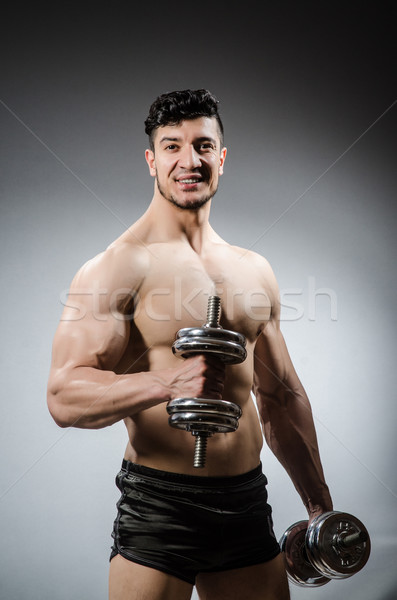 Stock photo: Muscular ripped bodybuilder with dumbbells