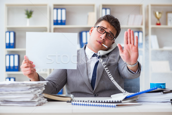 Businessman smoking at work in office holding a blank message bo Stock photo © Elnur