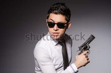 Young man in classic striped costume holding gun isolated on gra Stock photo © Elnur
