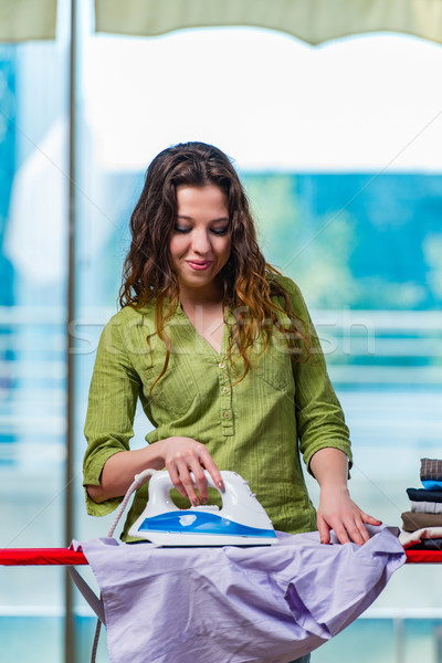Young woman ironing clothing on board Stock photo © Elnur
