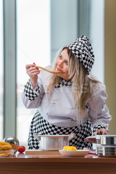 Stock photo: Female cook preparing soup in brightly lit kitchen
