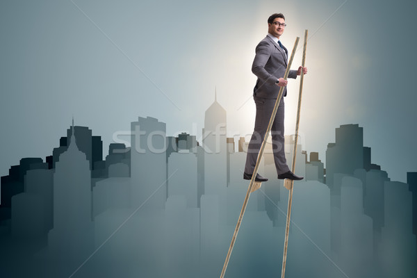 Businessman walking on stilts - standing out from the crowd Stock photo © Elnur