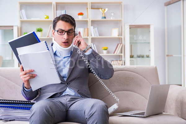 Man in neck brace cervical collar working from home teleworking Stock photo © Elnur