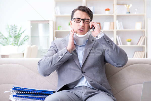 Man in neck brace cervical collar working from home teleworking Stock photo © Elnur