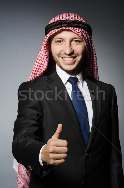 Arab businessman with thumbs up againt grey background Stock photo © Elnur