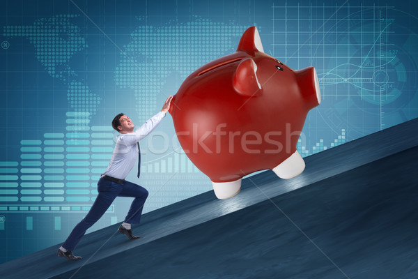Man pushing piggybank uphill in business concept Stock photo © Elnur