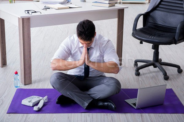 Man meditating in the office to cope with stress Stock photo © Elnur