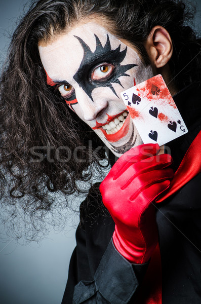 Evil clown with cards in dark room Stock photo © Elnur