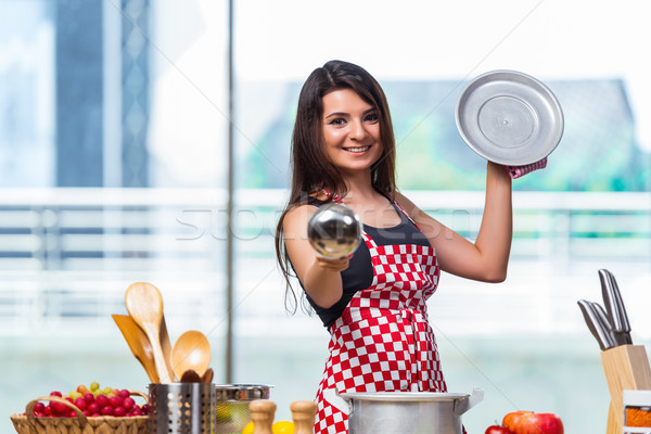 The female cook preparing soup in brightly lit kitchen Stock photo © Elnur