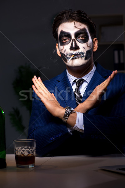Businessman with scary face mask working late in office Stock photo © Elnur