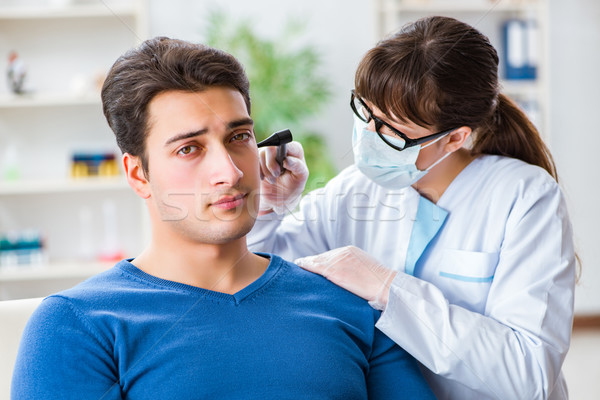 Doctor checking patients ear during medical examination Stock photo © Elnur