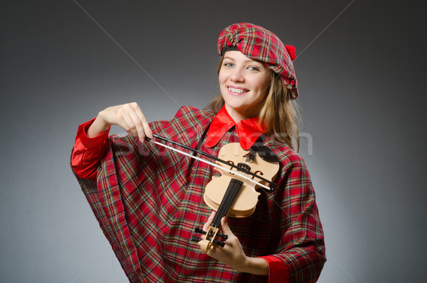 Stock photo: Woman in scottish clothing in musical concept