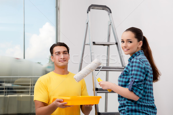 Stock photo: Young couple painting wall at home