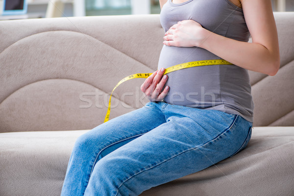 Mulher grávida barriga barriga sessão sofá casa Foto stock © Elnur