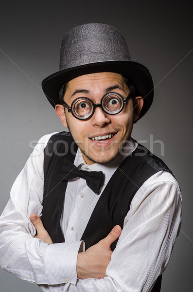 Stock photo: Young man in classical black vest and hat against gray