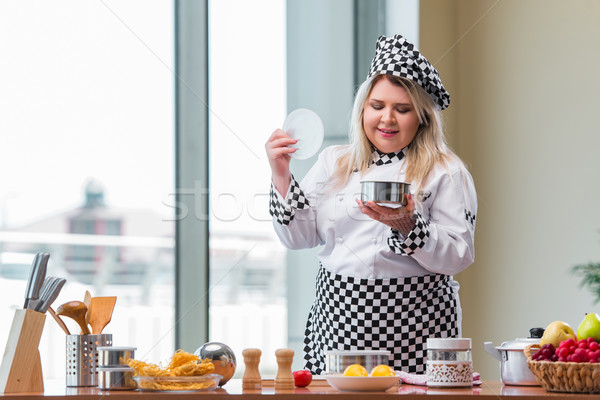 Stock photo: Female cook preparing soup in brightly lit kitchen