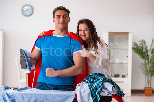 Stock photo: Super hero man husband ironing at home helping his wife