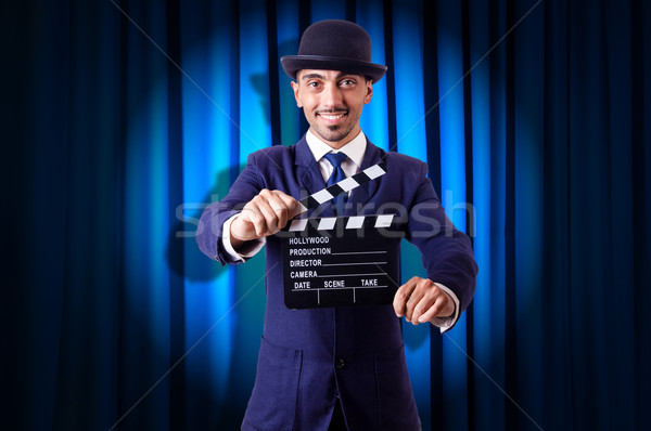Stock photo: Man with movie clapper on curtain background