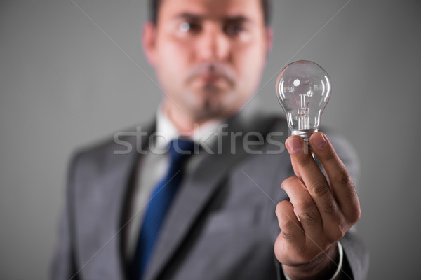 Businessman holding light bulb in creativity concept Stock photo © Elnur